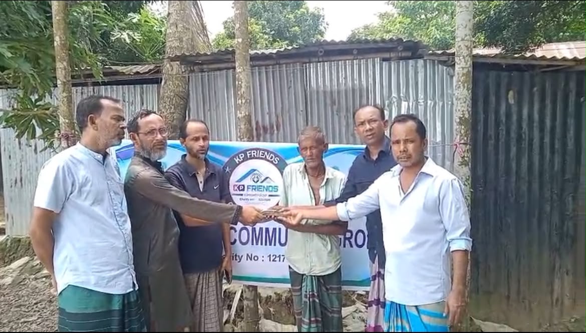 Volunteers presenting aid beside the KP Friends banner